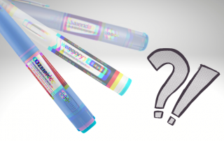 Three colorful markers labeled "Ozempic," "Wegovy," and "Saxenda" placed against a light background, with a question mark graphic next to them, suggesting inquiry or confusion about the products.