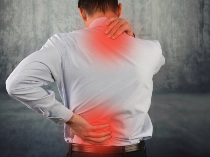 A man in a light blue shirt stands with his back to the camera, holding his lower back and neck, indicating discomfort. A red hue highlights the areas of pain, illustrating potential issues related to GLP-1 Skin Sensitivity (Allodynia) as seen with GLP-1 treatment.